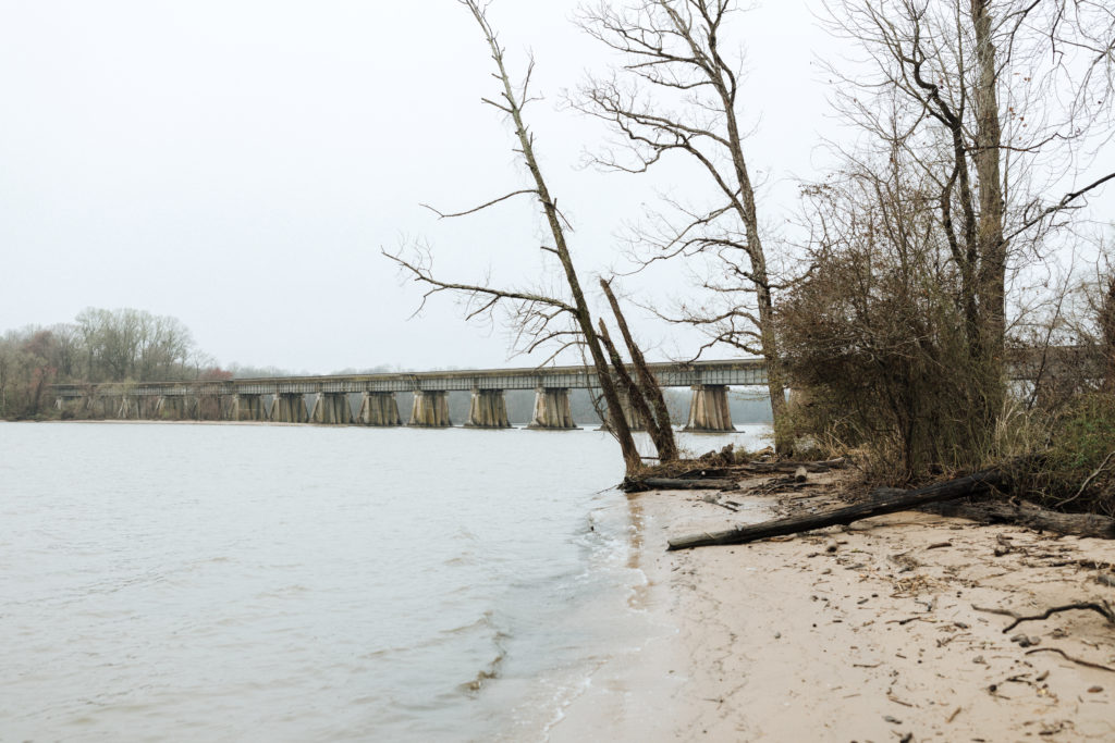 a small beach at leesylvania state park with a bridge in the distance
