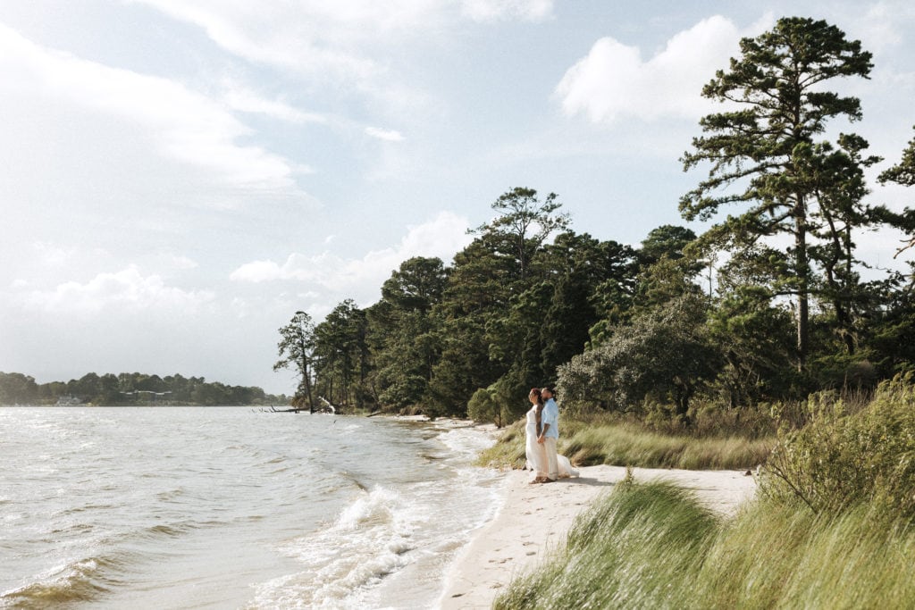 bride and groom overlooking first landing state park at the water's edge