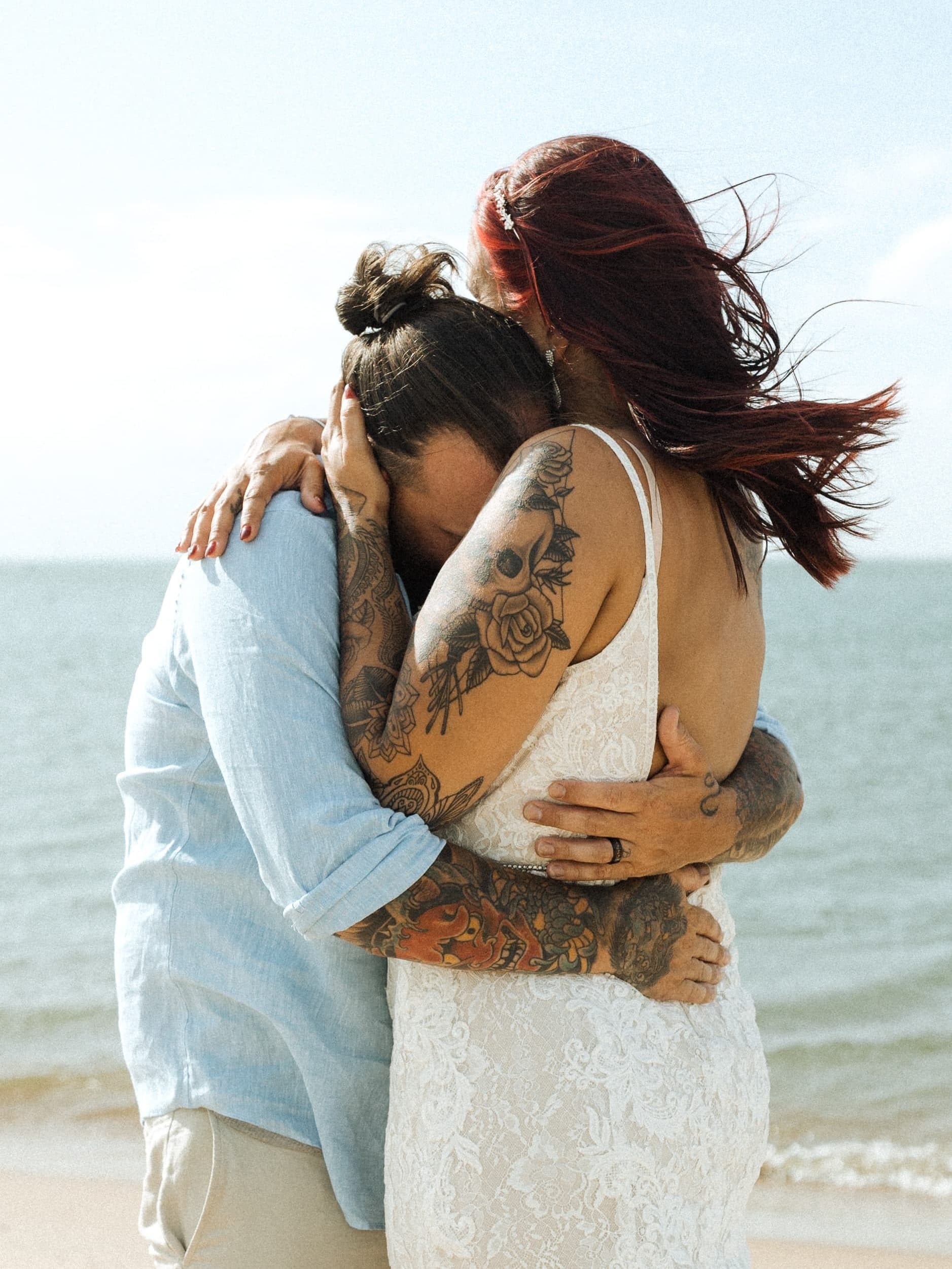 bride and groom hugging tenderly after their wedding ceremony on the beach