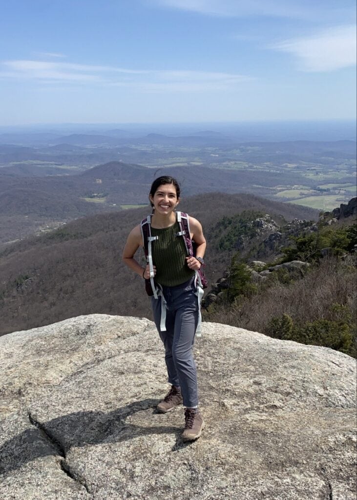 woman with hiking backpack smiling at camera at old rag summit