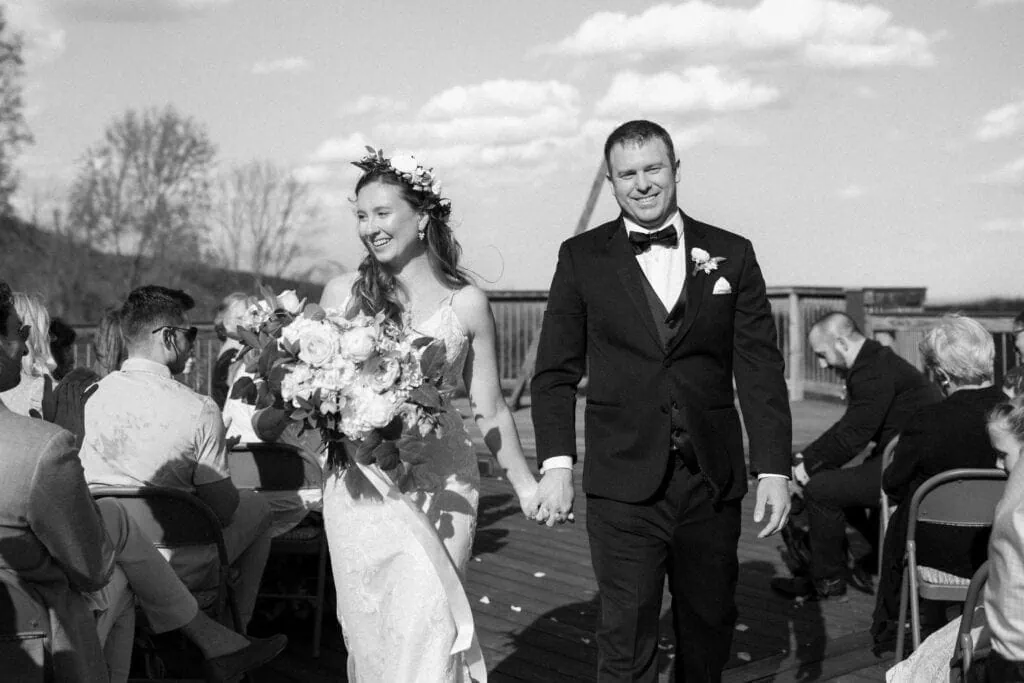 a bride and groom walk back down the aisle after being wed with smiles on their faces