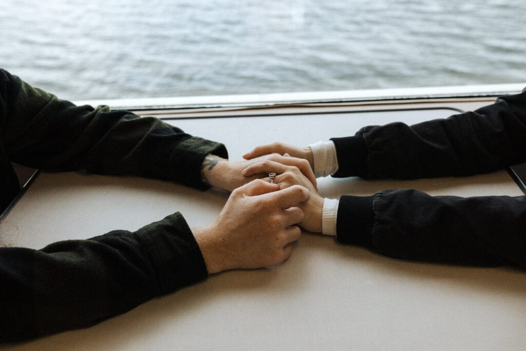 close up of a couples hands embracing from across the table