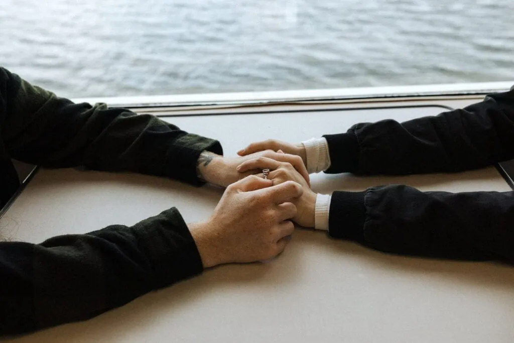 close up of a couples hands embracing from across the table