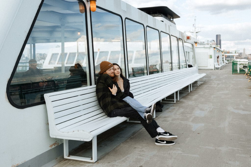 A couple embraces on a bench of a ferry